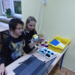 Uczniowie pracują na laptopach podczas warsztatów programowania.