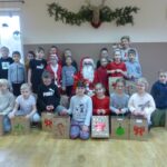 Dzieci pozują do zdjęcia z prezentami.