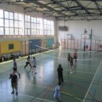 Uczniowie grają w siatkówkę i inne gry w sali gimnastycznej