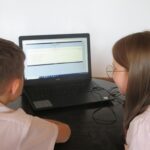 Uczniowie rozwiązują quiz na laptopie.