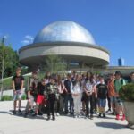 Uczniowie pozują do zdjęć na tle planetarium