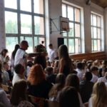 Uczniowie wręczają róże swoim rodzicom