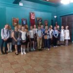 Uczniowie na tle masek teatralnych