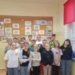 Uczniowie pozują na tle swoich prac plastycznych