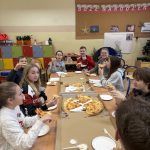 Uczniowie jedzą pizzę