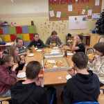 Uczniowie jedzą wspólny posiłek