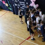 Uczniowie klasy 7 wręczają prezenty na zakończenie szkoły uczniom klasy 8